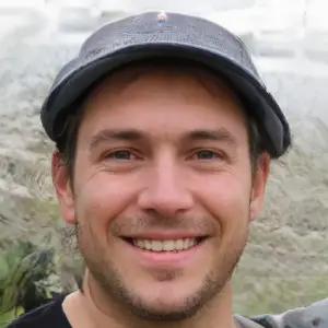 Smiling man wearing a gray baseball cap outdoors